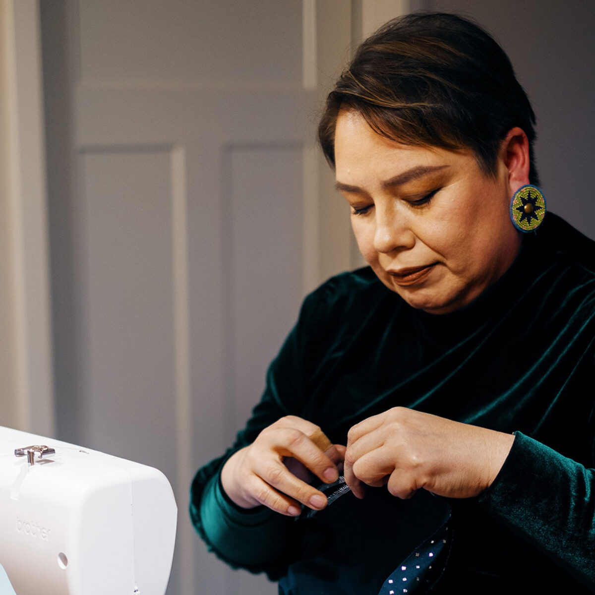 Raine sewing clothes at her sewing machine
