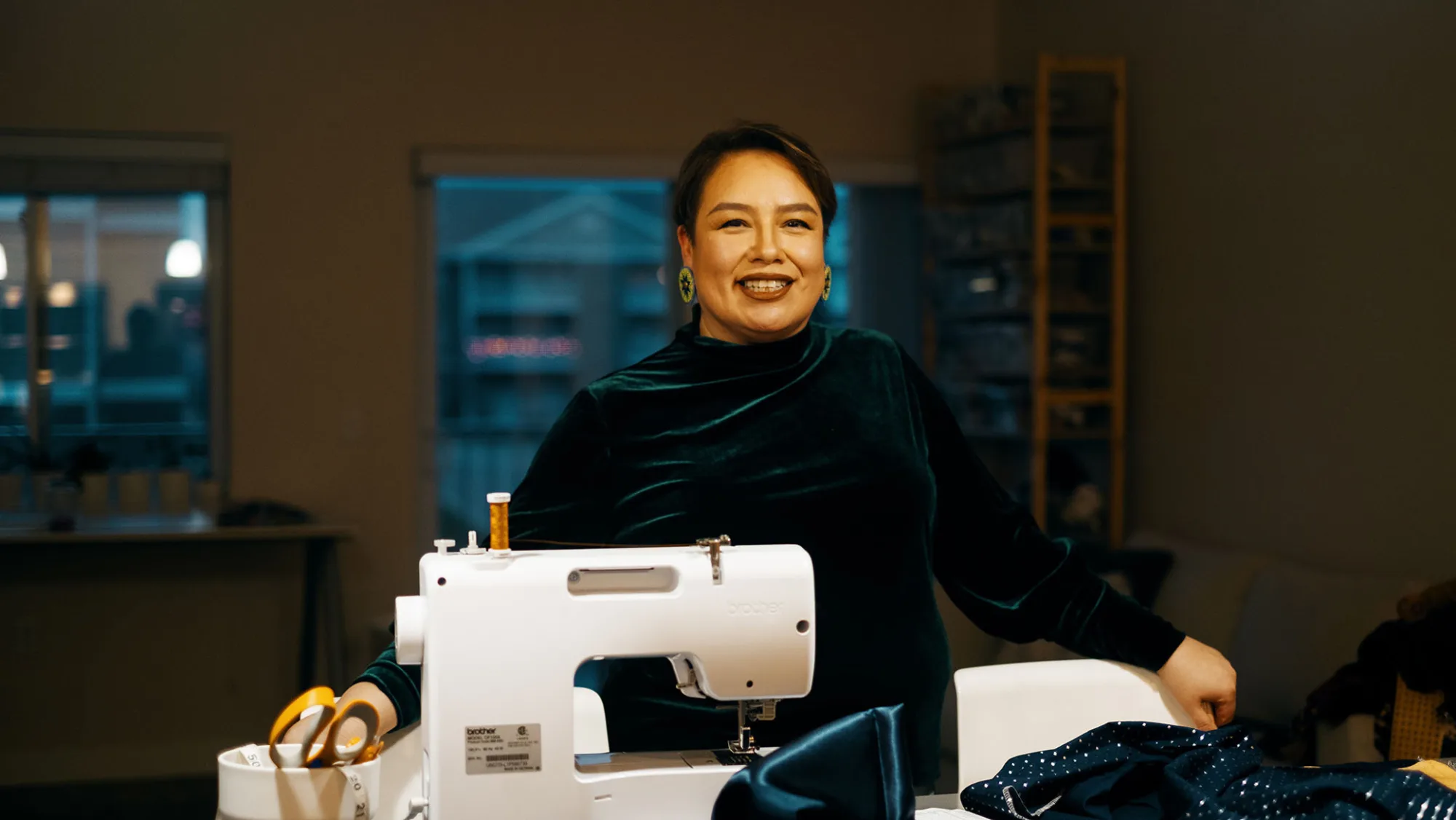 Raine standing next to her sewing machine