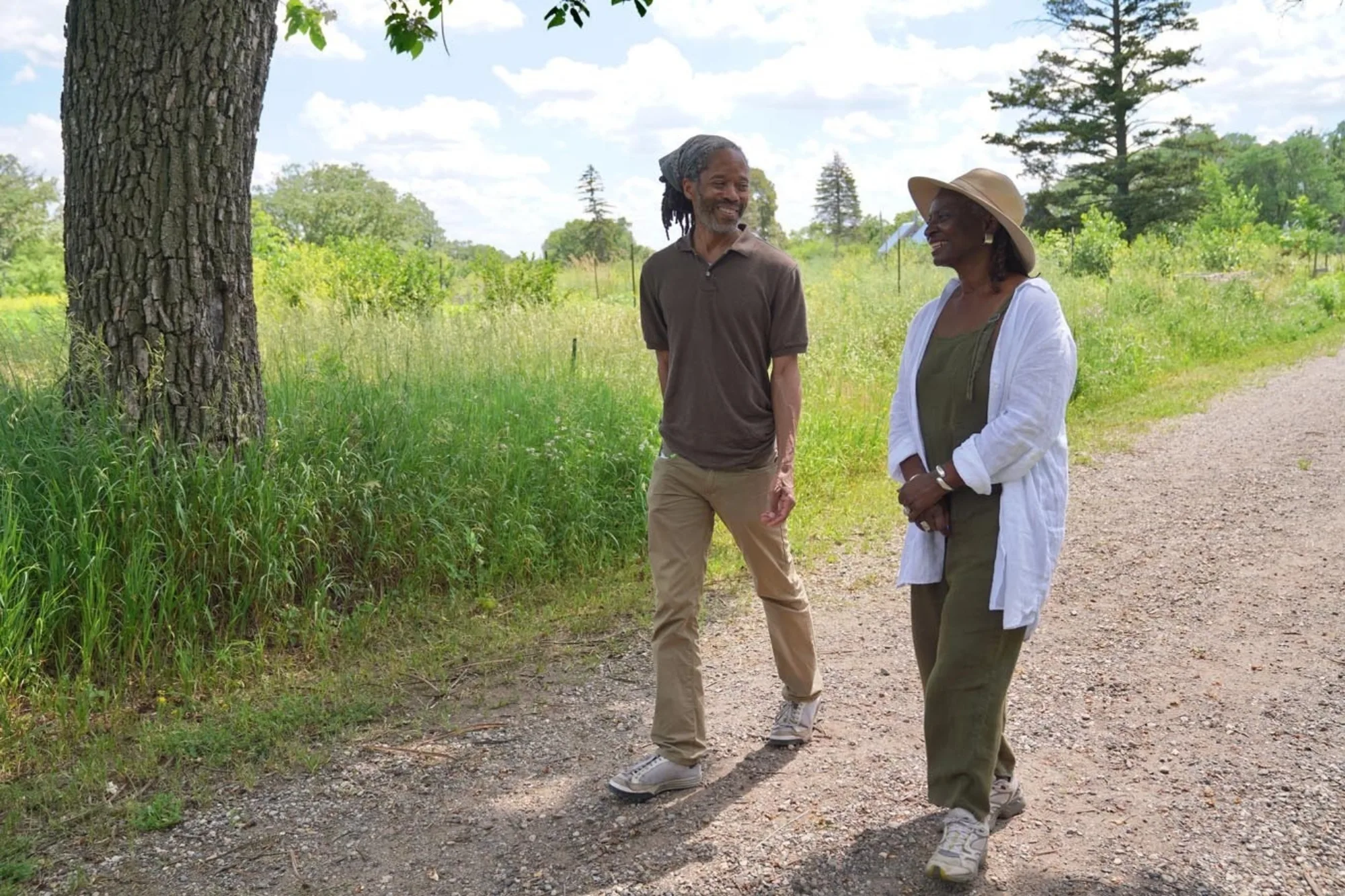 GE Patterson and Soyini Guyton walking down a dirt path on Frogtown Farm