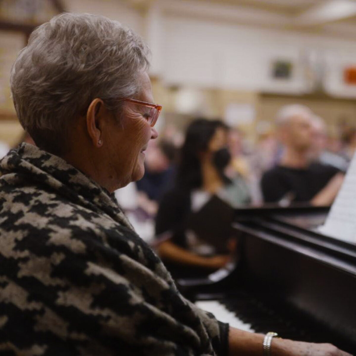 Accompanist seated at the piano during a rehearsal