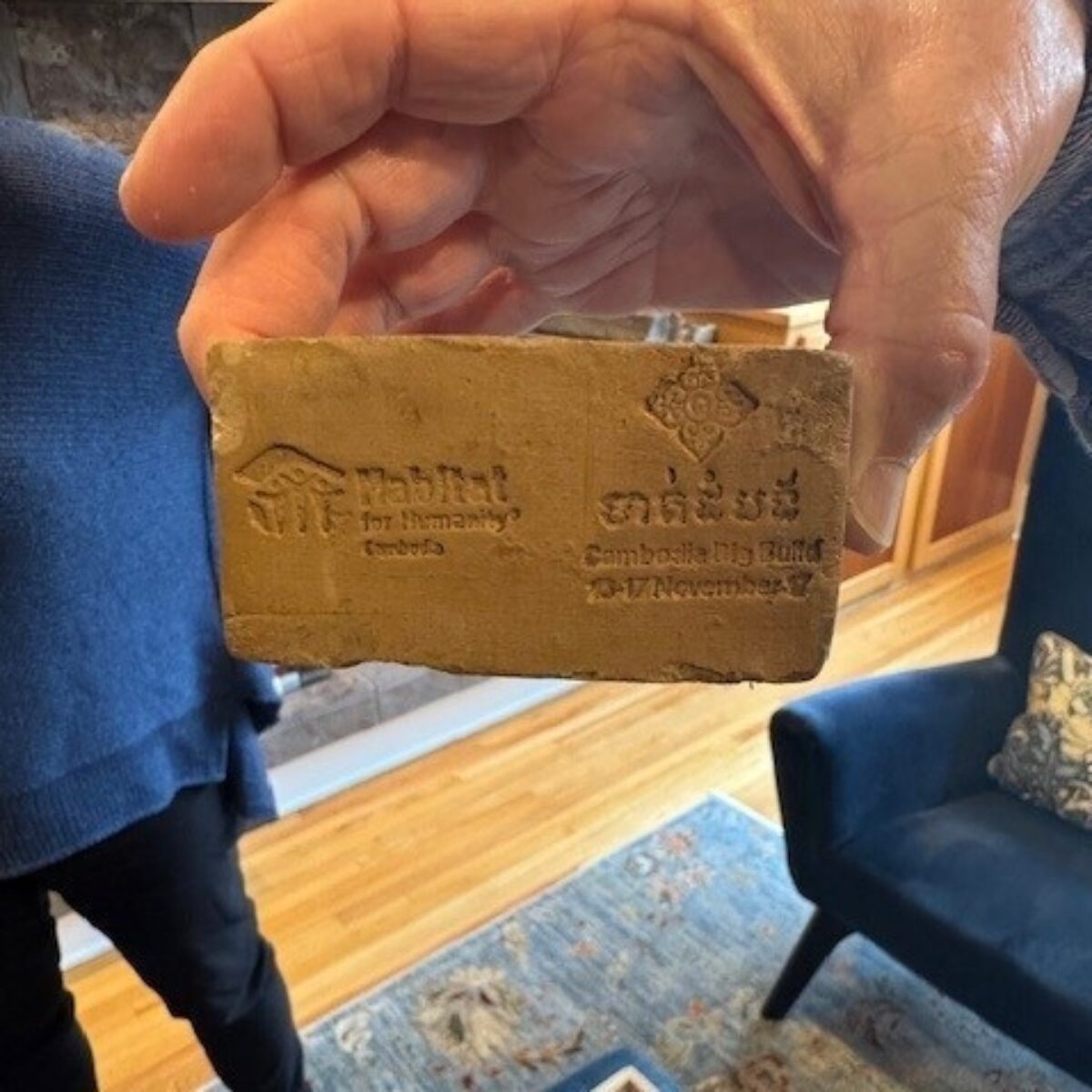 Lee holding a Habitat for Humanity brick