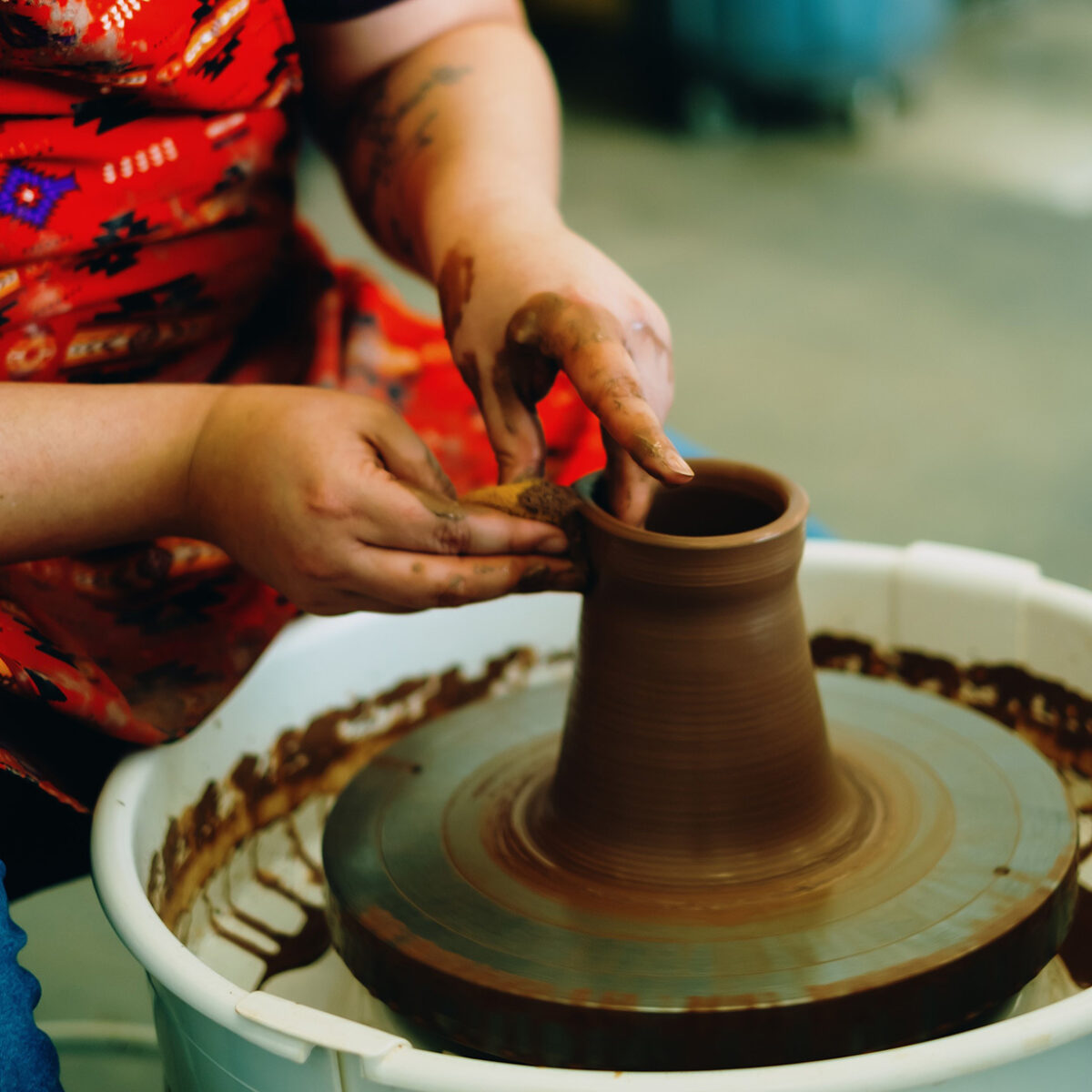 Rochelle forming clay on a potters wheel