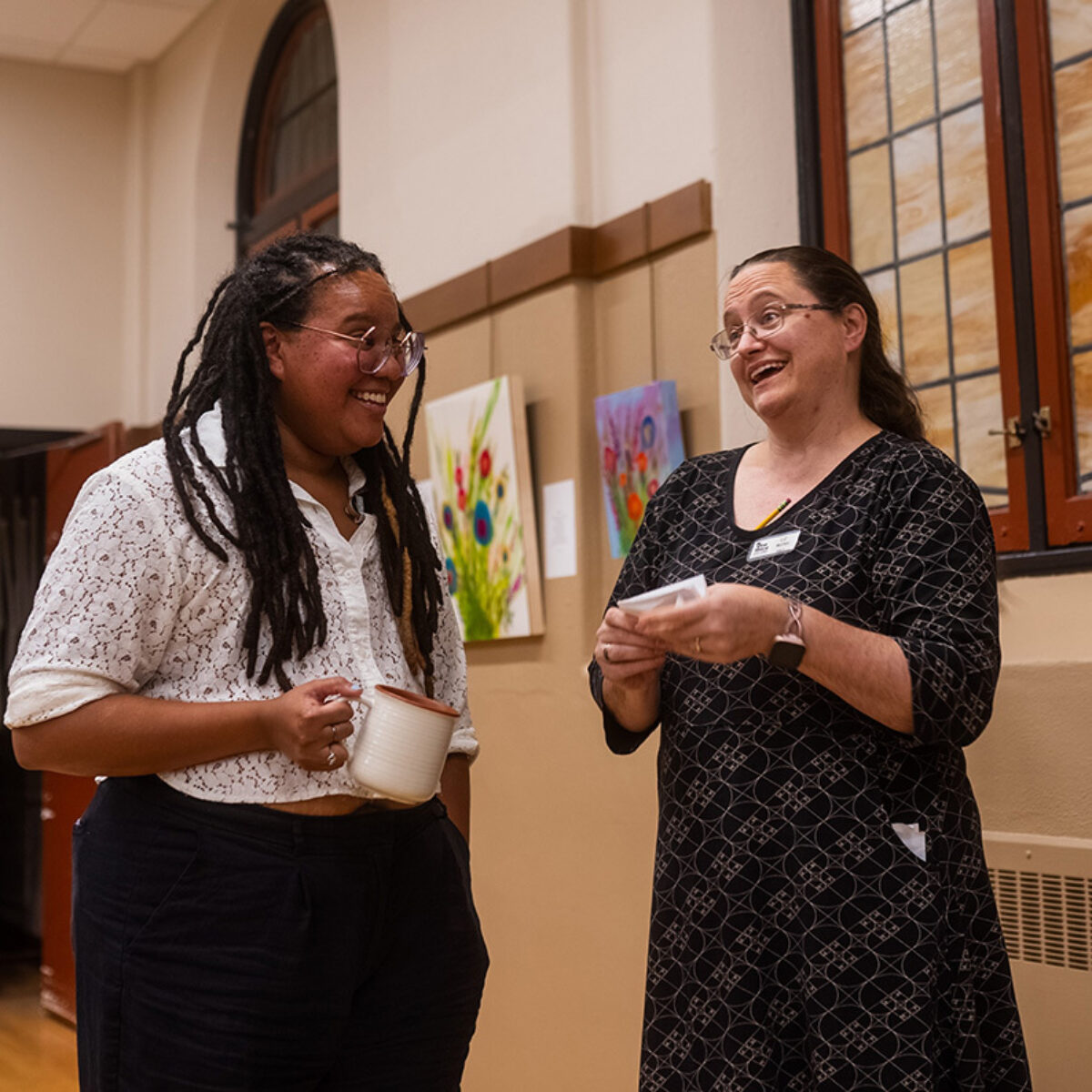 Waigwa laughing with a member of the choir
