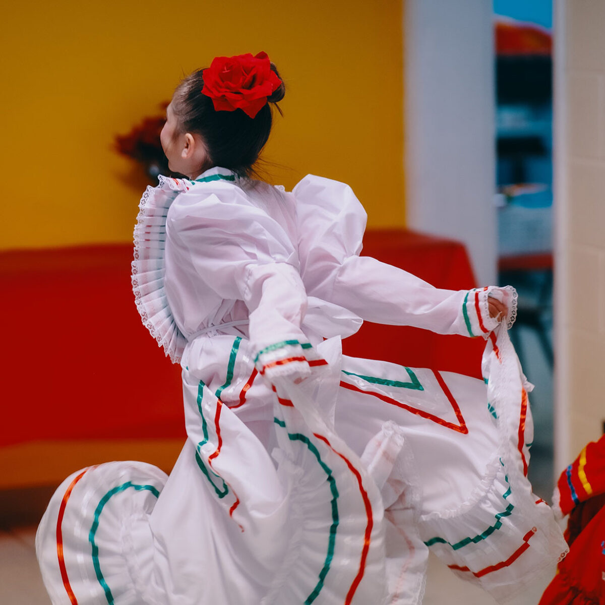 Young girl dancing in a traditional white dance dress