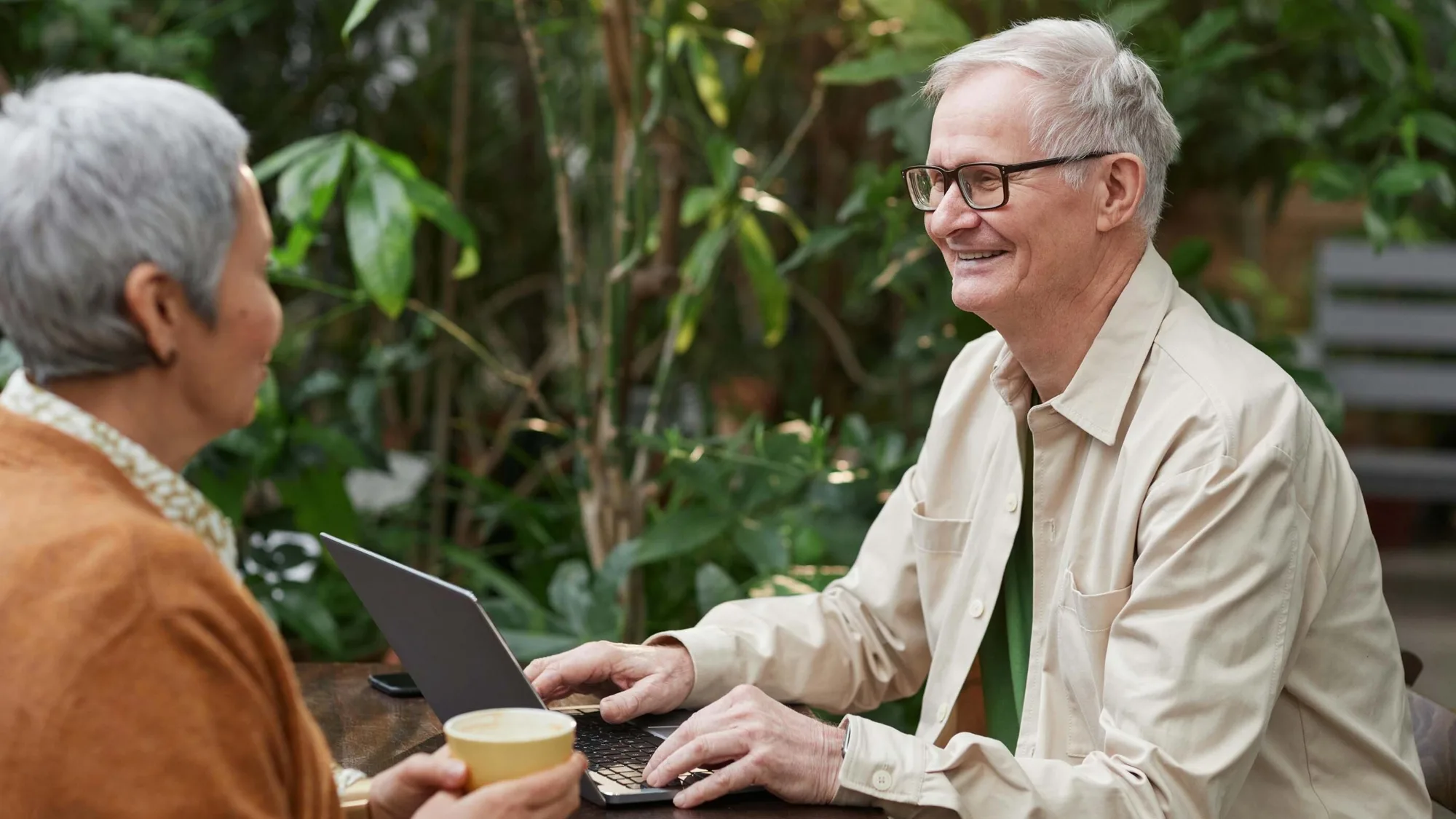 Older couple with a laptop at a picnic table