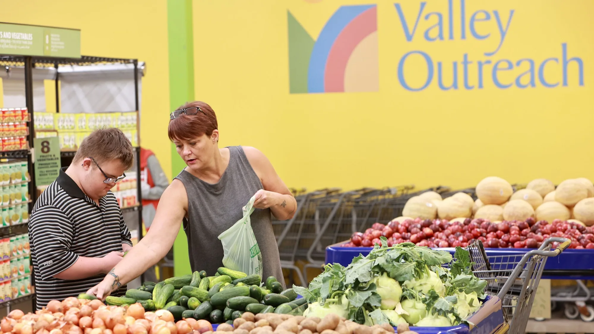 Two people picking out produce at Valley Outreach 16x9