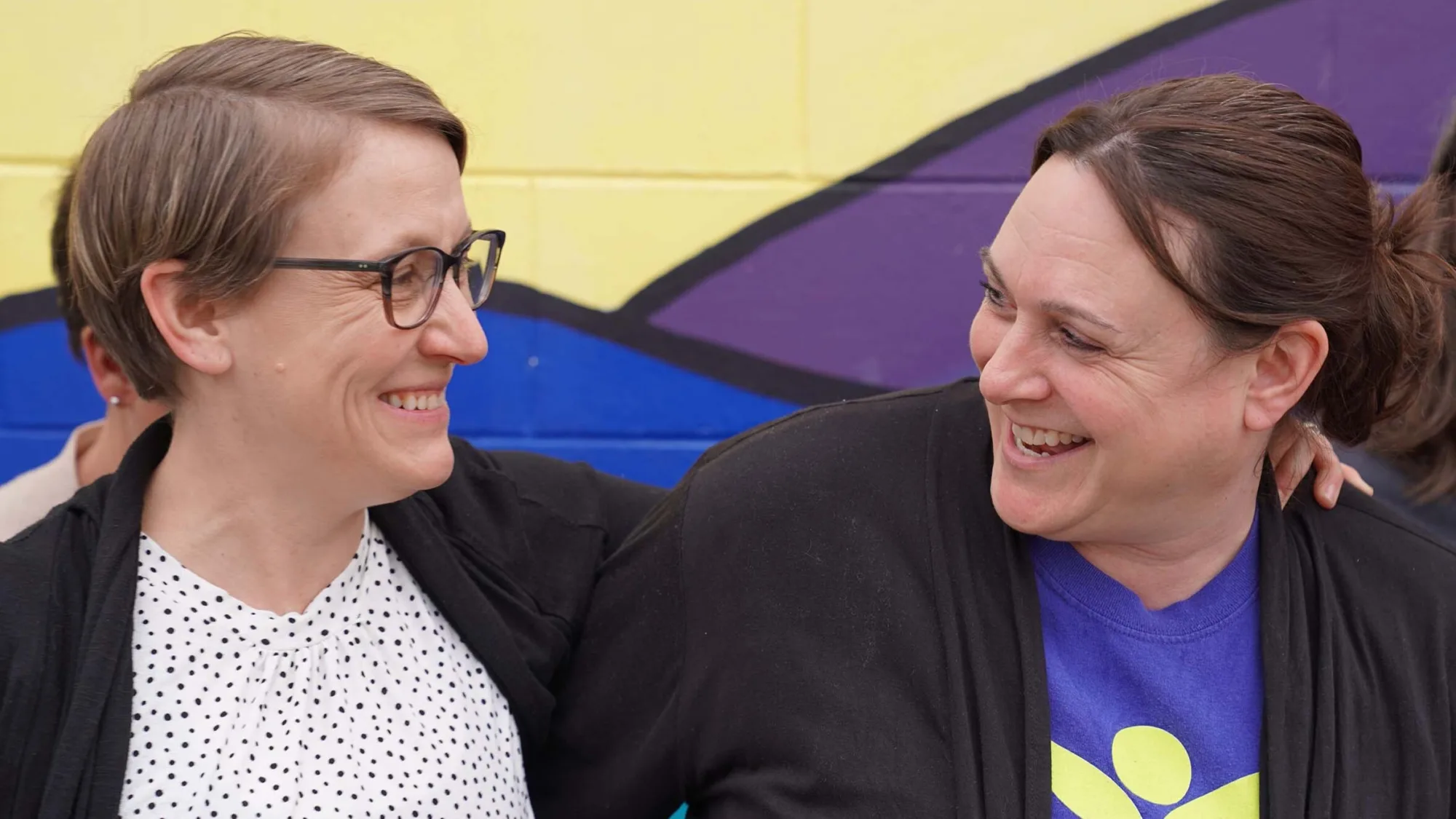 Two women smiling outside of Hastings Family Service building