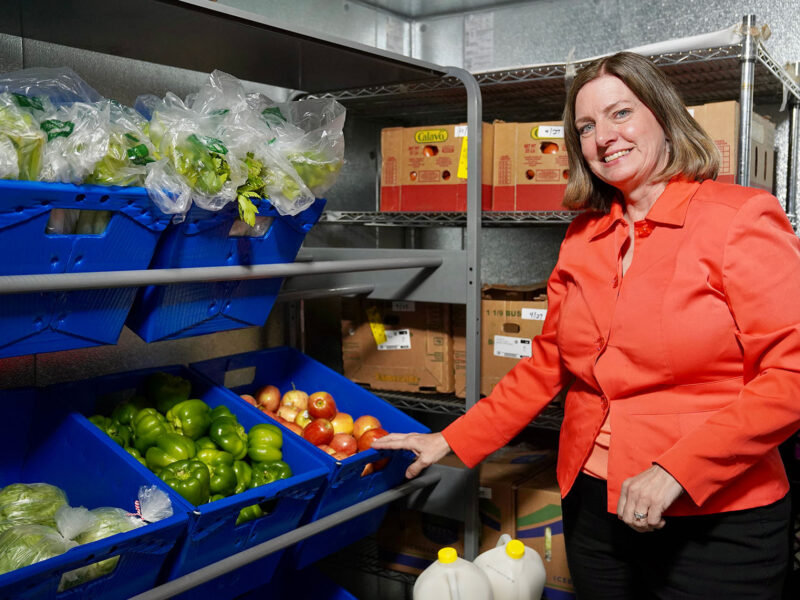 Amy standing next to bins of produce
