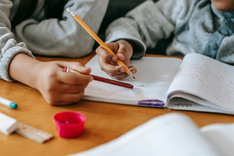 Community Solutions Teacher helping a student with his homework
